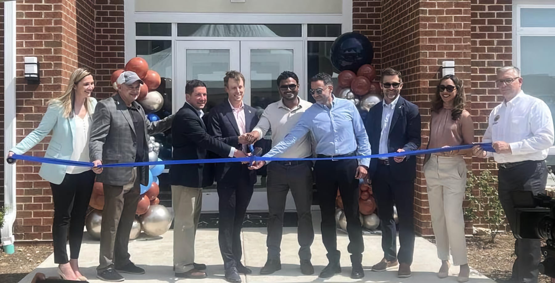 Group Ribbon Cutting Ceremony at Building Entrance