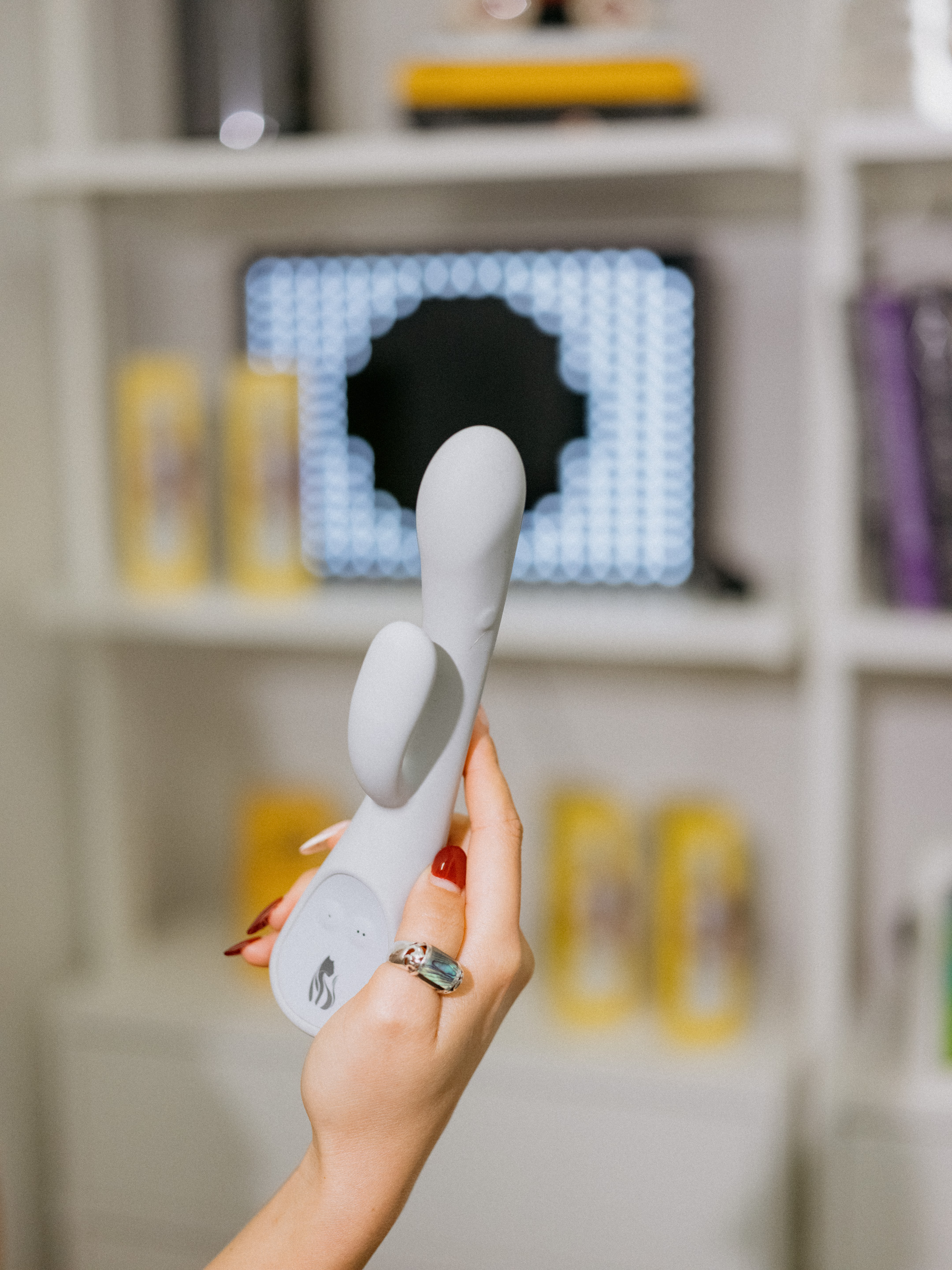 Hand Holding Gray Rabbit Vibrator in Home Setting